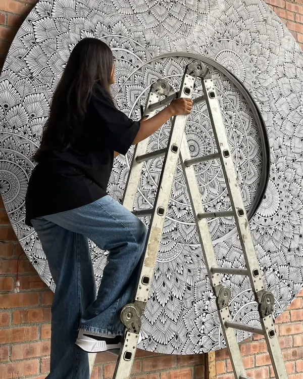 Up on a ladder, adding details to the massive 10 foot mandala mural in Malaysia. This project required focus, patience, and a steady hand.