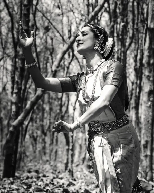 A black and white portrait from a photoshoot in the woods. The natural textures of the forest create a beautiful, timeless backdrop for the dance posture.