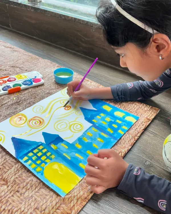 A young artist channeling her inner Van Gogh! Here she is, creating the beautiful swirls of a 'Starry Night' sky. It's a wonderful way to learn about brushstrokes and color.