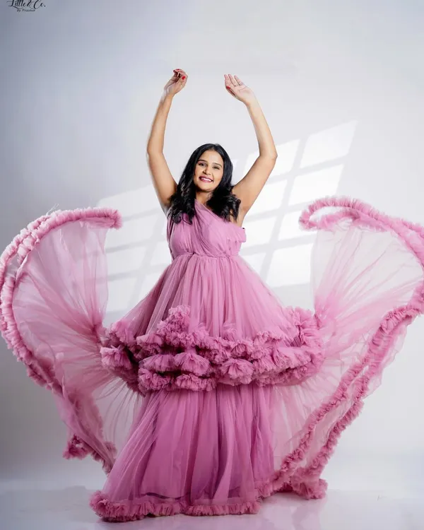 A moment of pure joy captured in our pink ruffled gown. The movement of the dress adds a dynamic and celebratory feel to this solo maternity portrait.