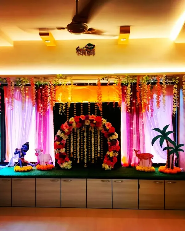 A beautiful Vrindavan-themed Ganpati decoration for the home. This setup features a floral arch, props like a Krishna idol and a cow, and traditional marigold garlands.