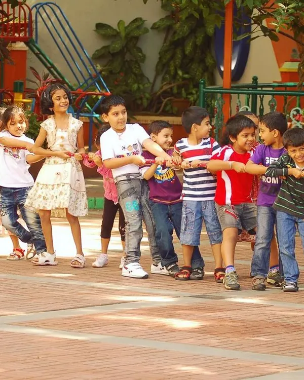 A classic game of tug-of-war is one of the best ways to teach children about teamwork and collective strength. Look at the determination and joy on their faces as they work together in this fun group activity.