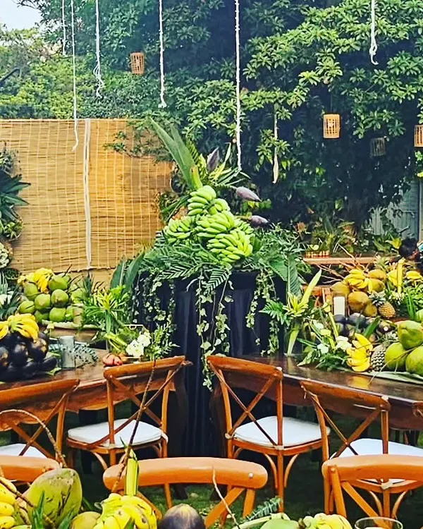 This was the showstopper for a rustic sit-down dinner. The tables were decorated with an abundance of fruits and foliage, including bananas, coconuts, and pineapples, all sourced from the client's own farm for a true farm-to-table experience.
