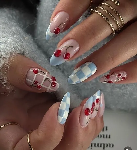 The cherry nail trend is so cute and versatile. Here it's paired with a baby blue checkerboard pattern for a playful, retro vibe.