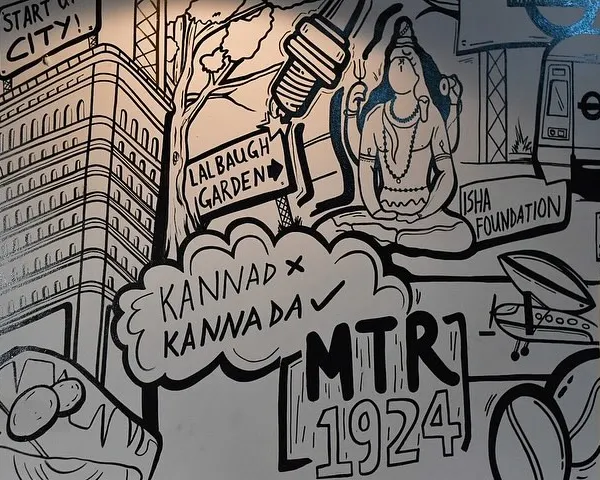 A close-up of our 'Namma Bengaluru' doodle art, showing details like the Isha Foundation Adiyogi statue and Lalbagh Garden signs. This kind of detailed line art is perfect for giving customers something new to discover with every visit.