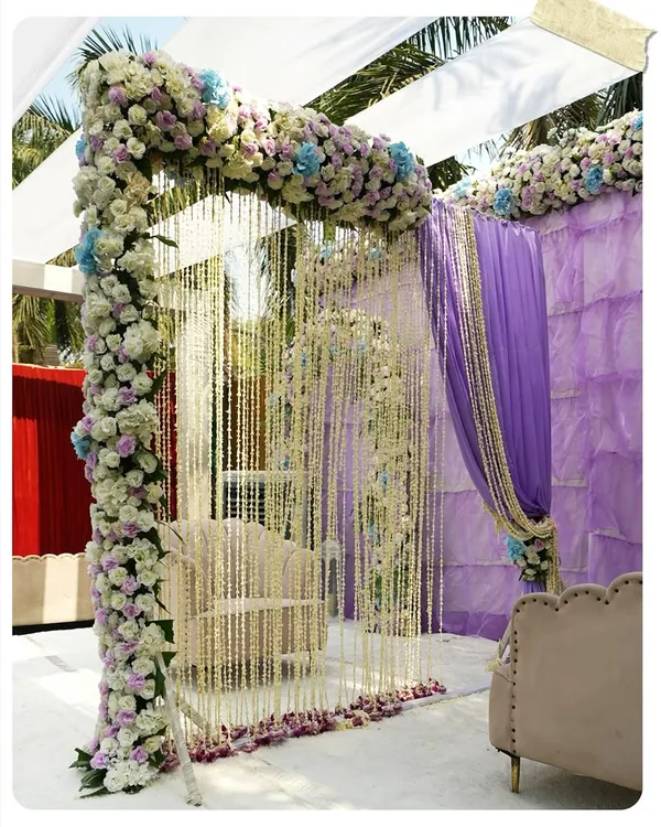 A breathtaking Nikah ceremony setup. The delicate curtain of white floral strings creates an ethereal and intimate space, framed by a beautiful arch of pastel flowers.