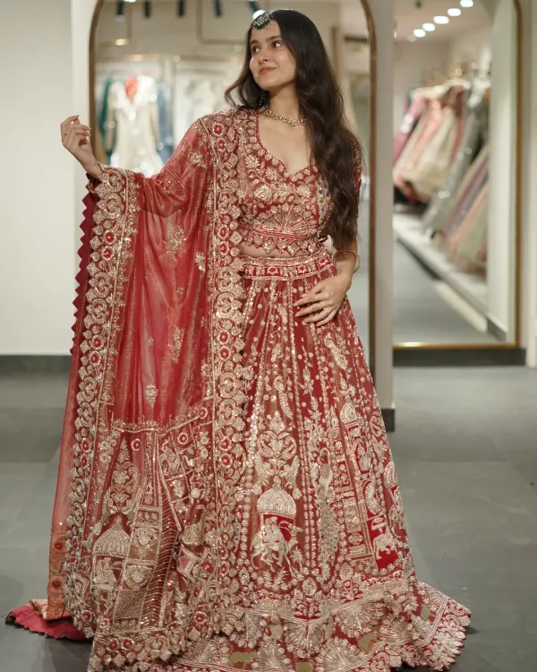 A full view of a breathtaking maroon bridal lehenga. The intricate, dense embroidery covers the entire skirt and blouse, creating a look of pure opulence perfect for your wedding ceremony.