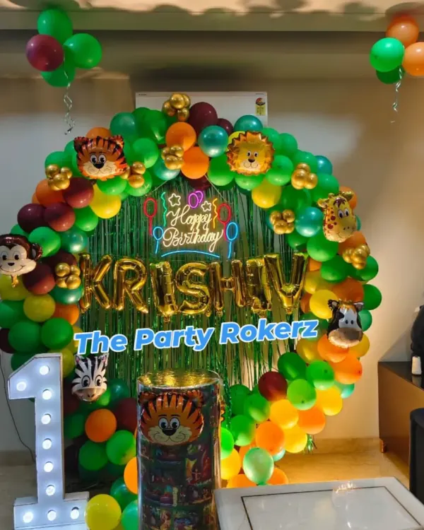 A classic jungle theme setup for a first birthday at home. I used a round balloon arch with lots of green, animal foil balloons, a custom backdrop, and a light-up number '1'.