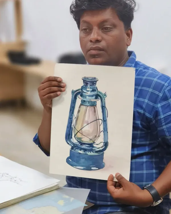 Our instructor, Sushil, holds up a finished watercolor study of a lantern. In his sessions, he breaks down complex objects into simple shapes and values, making realistic painting accessible even for beginners.
