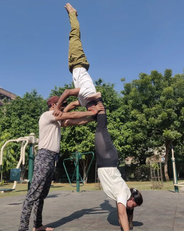 This three person acro yoga pose requires a lot of balance, communication, and trust. It's a perfect example of how we can work together to create something beautiful and strong.