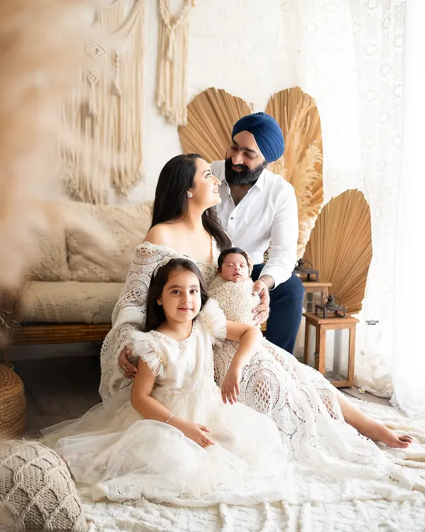 Welcoming a new baby is a milestone for the whole family. This beautiful portrait captures the love and excitement of parents and a big sister meeting the newest member.