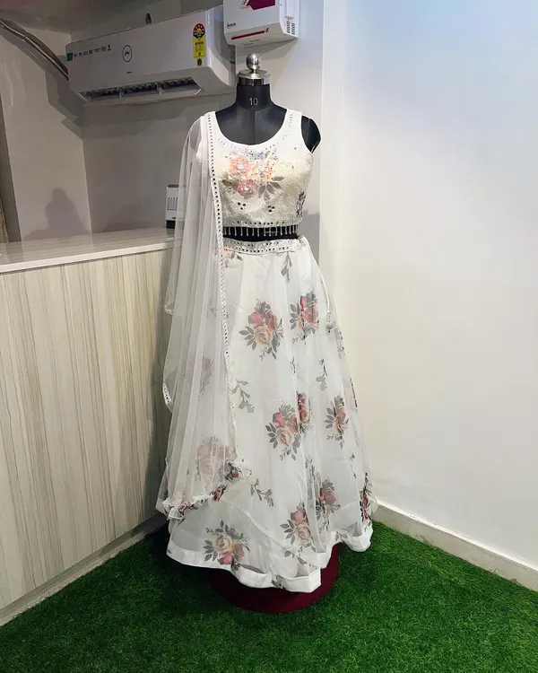 This white floral lehenga is a dream for a day wedding. The light organza fabric and soft floral print are complemented by a sequined blouse and a stylish embellished belt.