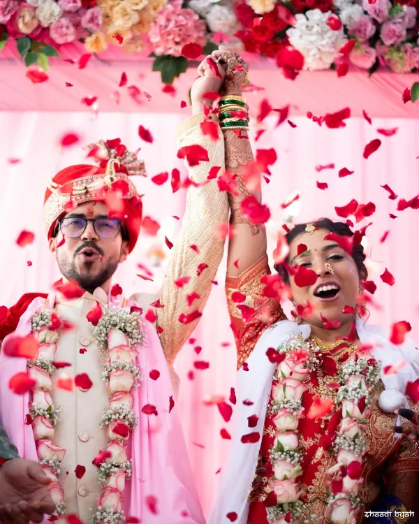 The moment of celebration. An explosion of rose petals as the couple is officially declared married. This is pure joy.