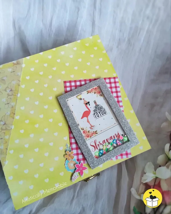 The lid of a bright yellow birthday hamper, decorated with a personalized shaker frame for Shravani. I love making the box as special as the gifts inside.