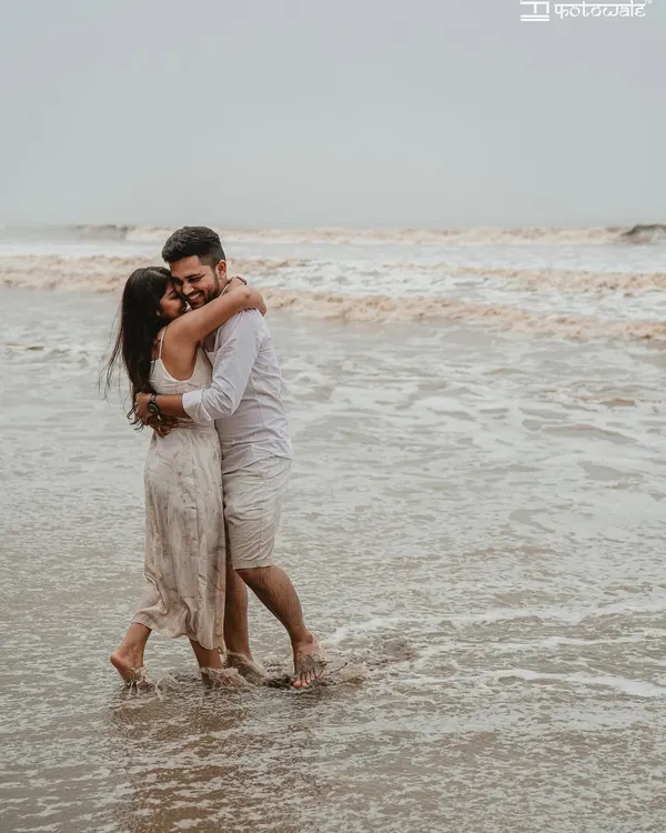 A deeply romantic and candid moment of the couple embracing in the waves. This pre-wedding beach photo is all about raw emotion and the feeling of being lost in each other.