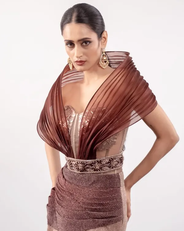 This is a true couture moment. I designed this piece with a dramatic power shoulder corset and an ombré draped skirt, embellished with hand-embroidered floral motifs for a look that is both powerful and romantic.