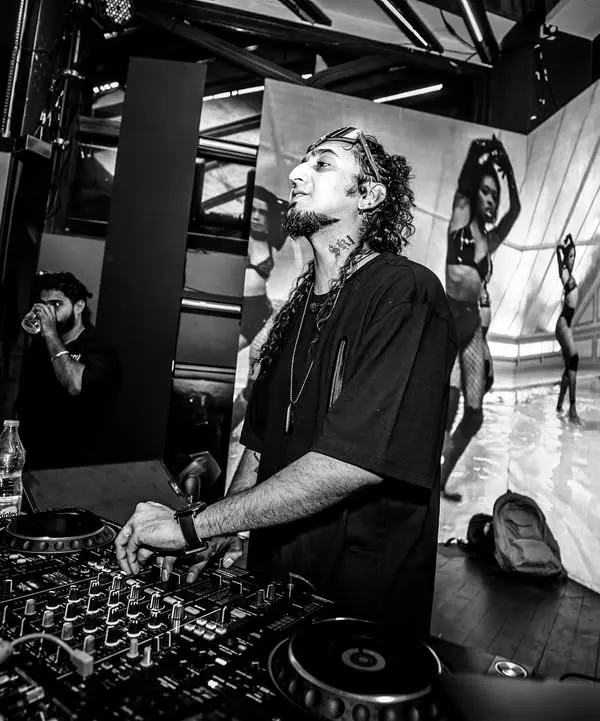 A black and white shot of me at the decks with a massive video wall behind me. The visuals are just as important as the music in my sets.