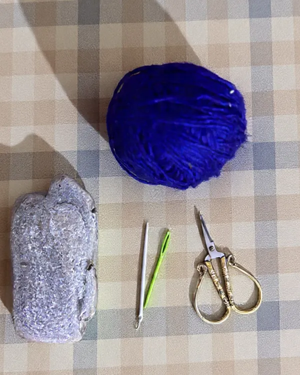 The materials for this project are beautifully simple: a smooth stone, some colorful yarn, a needle, and scissors. This shows that you can create something meaningful with just a few basic elements and a bit of time.