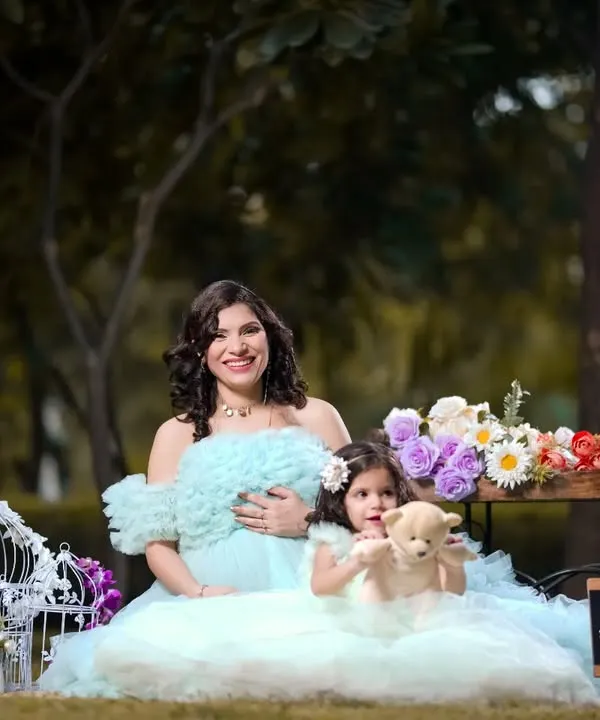 Happiness is on the way, and big sister is ready to welcome it. This sweet outdoor family portrait captures a beautiful moment between mother and daughter.