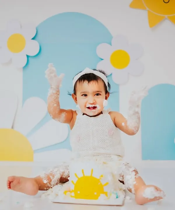 Hands up if you love cake. This little ray of sunshine is having a blast during her daisy and sun themed cake smash session, a perfect theme for a bright and happy baby.