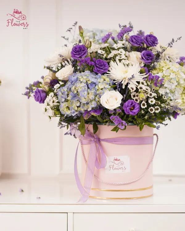 This is one of my signature luxury flower boxes, featuring a lush mix of purple eustoma, soft blue hydrangeas, and crisp white chrysanthemums. The arrangement is presented in a chic pink bucket box, making it a ready-to-display centerpiece for any occasion.