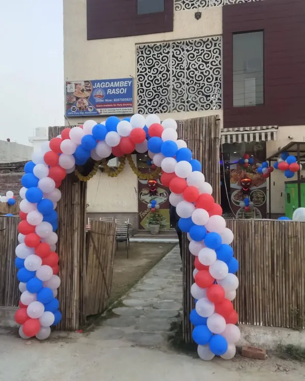 This large red, white, and blue balloon arch at a restaurant entrance is a perfect example of how I create high-impact decorations for grand openings and special events.