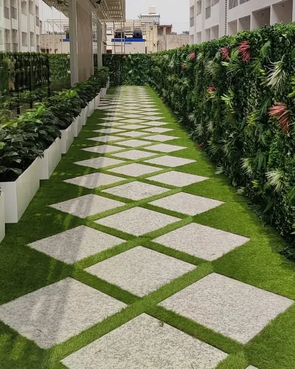 We transformed this commercial walkway for a leading fashion brand with a combination of our key services. This installation features durable artificial turf with inlaid stone pavers, bordered by a lush, multi-textured artificial green wall and sleek white planters.