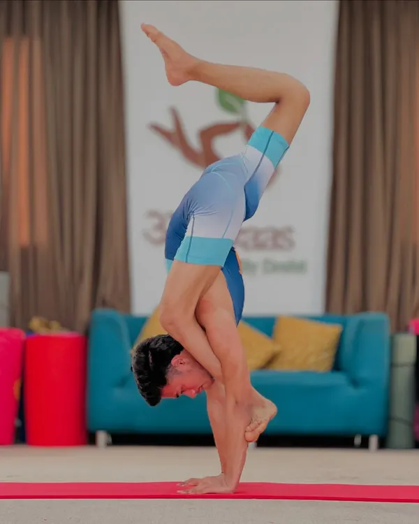 This is an advanced handstand variation, a pose that demands total body control and focus. With consistent practice, you can become unstoppable.