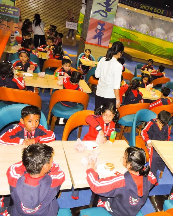 A class of uniformed students enjoying their meal at our Snack Box cafe during a school trip. We can accommodate large groups for both play and food.