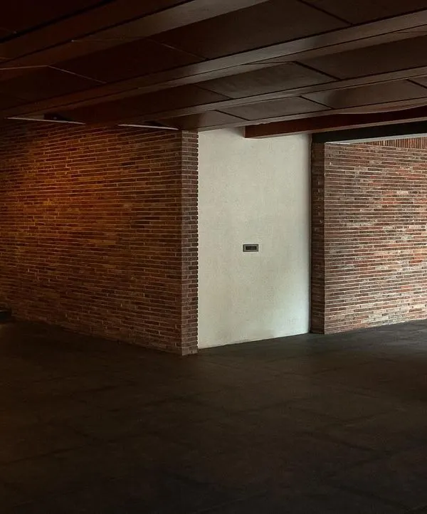 The entrance area of the Samavana wedding venue, featuring exposed brick walls and a wooden ceiling. The design blends contemporary lines with traditional materials to create a warm and welcoming atmosphere.