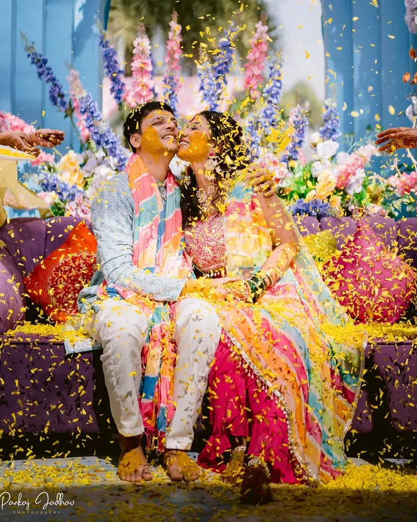 A shower of love and marigold petals. This shot from Laxmi and Roshan's Haldi is the epitome of joyful celebration, with vibrant colors and pure happiness.