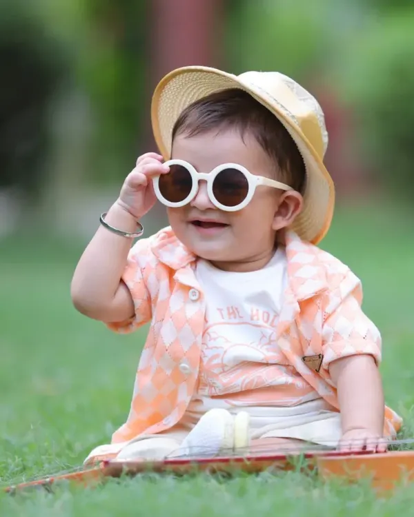We capture your child's personality in our fun and stylish outdoor photoshoots. This cool little guy is rocking his shades in a natural park setting, perfect for candid and relaxed portraits.