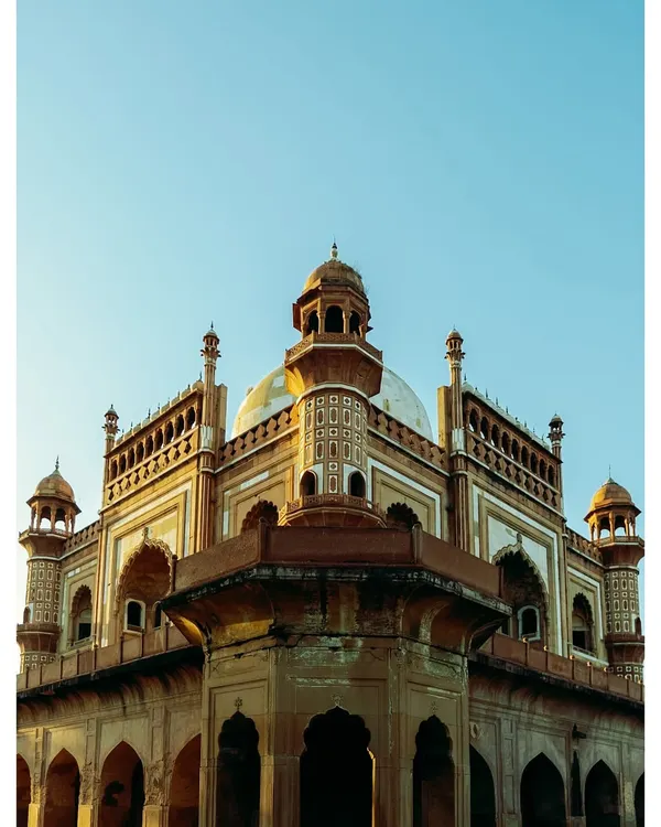 The magnificent facade of Safdarjung's Tomb, captured in the warm light of the golden hour. The sandstone and marble structure is a testament to the last phase of Mughal architecture in Delhi.