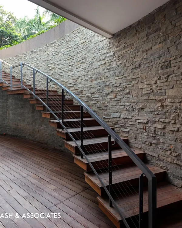 This outdoor staircase combines the warmth of wooden treads with the raw texture of a stone wall, creating a beautiful and durable transition to an entertainment area.