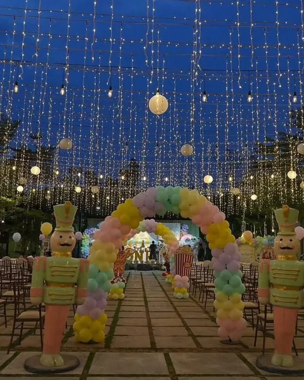 A truly magical entrance for Vihaan's carnival party. The entire walkway was covered in a canopy of fairy lights, leading to a pastel balloon arch and creating an unforgettable nighttime spectacle.