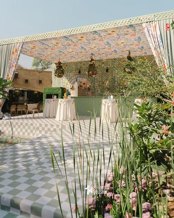 This enchanting garden setting captures our flair for creating complete sensory experiences. We combined a custom floral canopy, a checkered dance floor, and lush greenery to craft a whimsical atmosphere for a sunlit celebration.