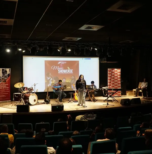 A wide shot of our student music showcase in Thane, with a full band on stage performing for a packed auditorium. These recitals are a core part of our curriculum, giving students a professional platform to demonstrate their skills.