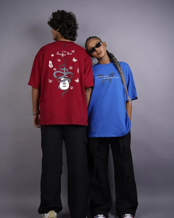 This shot captures the cool, relaxed vibe of a streetwear collection. The models' back-to-back pose is perfect for showing off the graphic designs on the oversized tees, creating a balanced and eye-catching composition.