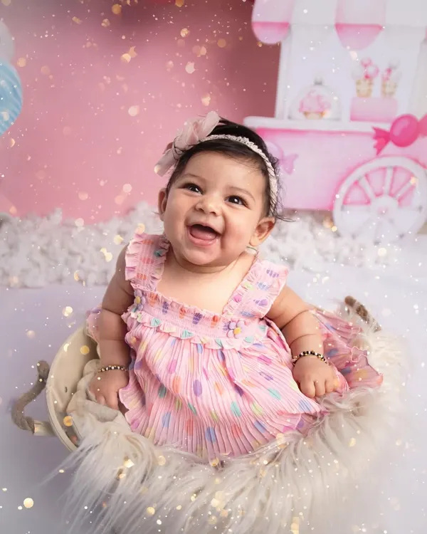This is one of my personal favourites! I just love the pure joy on this little one's face during her 'Candyland' themed sitter session. We created this sweet setup with a candy cart, fluffy clouds, and lots of pink to celebrate her half-birthday milestone.