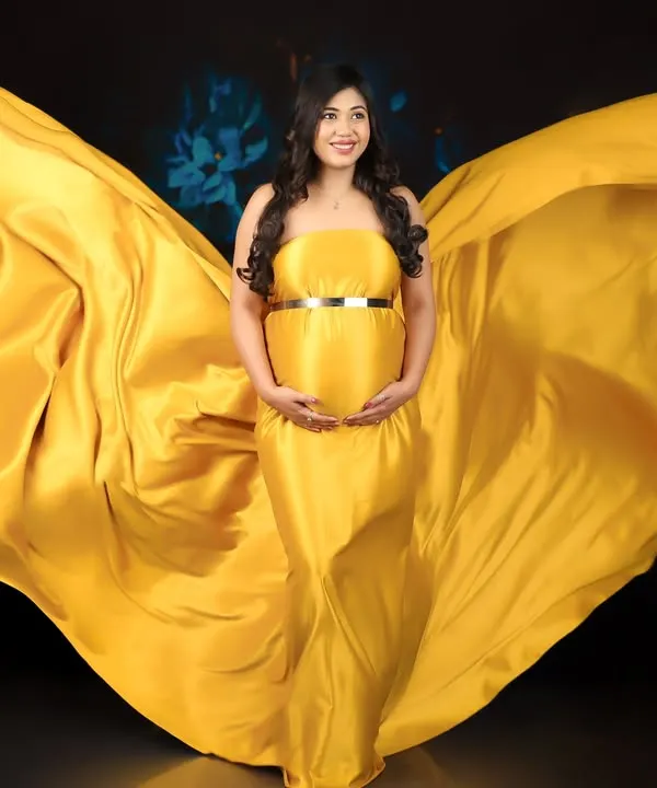 Feel like a goddess with my artistic fabric draping. This vibrant yellow fabric is expertly styled to create a breathtaking "wings" effect for a truly epic maternity photo.