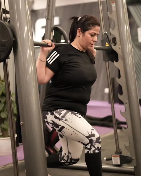 A member performs lunges on the Smith machine, a great exercise for targeting the quads and glutes with added stability and control.