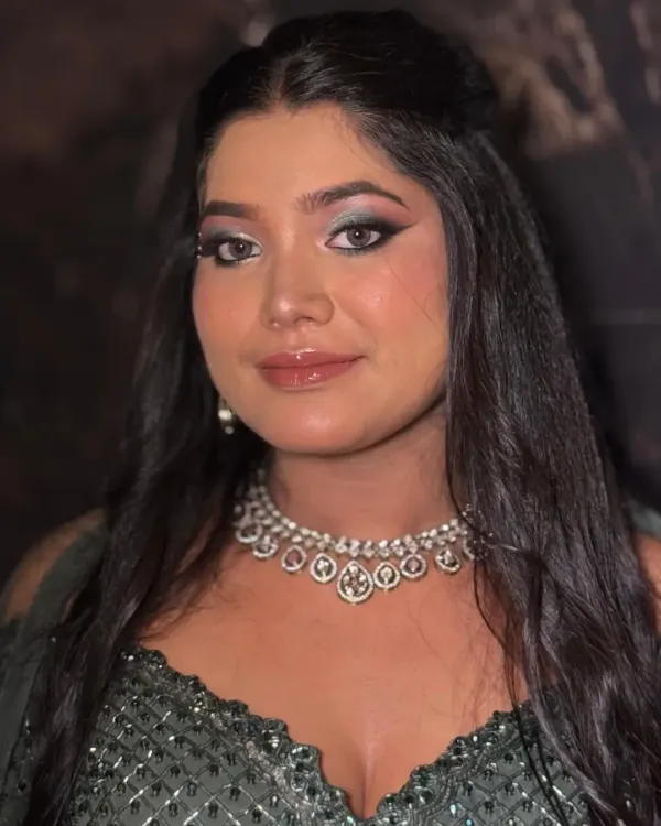 A direct, confident portrait showcasing a dramatic smokey eye. The intense eye makeup is balanced with glossy lips and glowing skin for a powerful yet feminine look.