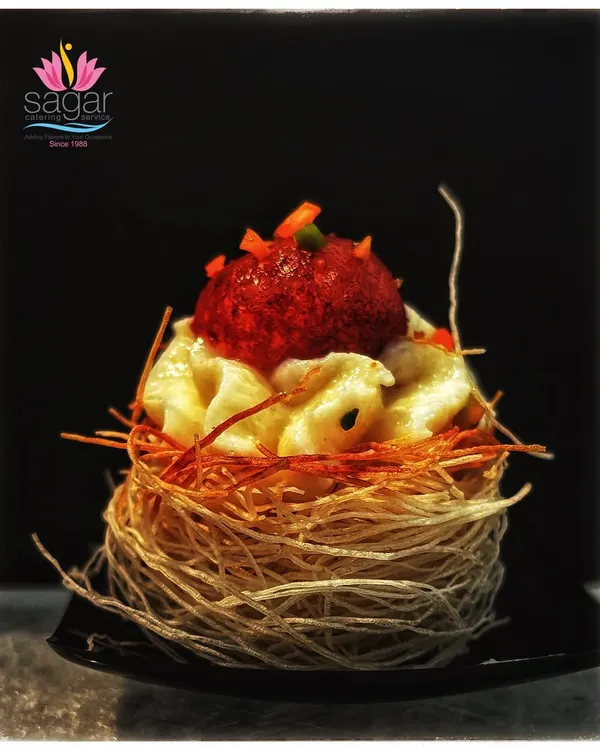 This is one of my signature fusion creations: a soft, syrup-soaked gulab jamun nestled inside a crispy, golden kunefe nest. It's a perfect example of how I blend traditional Indian sweets with Middle Eastern textures for a unique dessert experience.