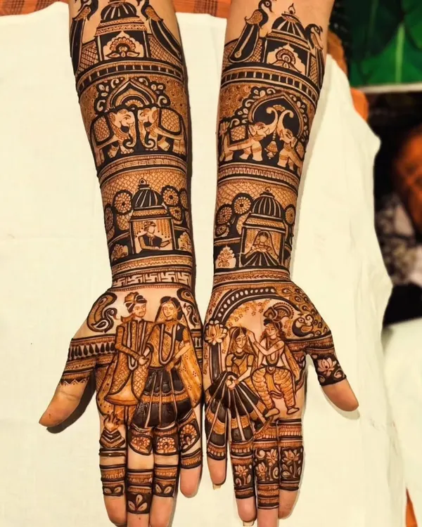 This full-arm bridal mehendi is a perfect example of telling a story. It features a detailed varmala ceremony on the palms, surrounded by traditional elements like elephants and royal jharokhas, creating a complete wedding narrative.