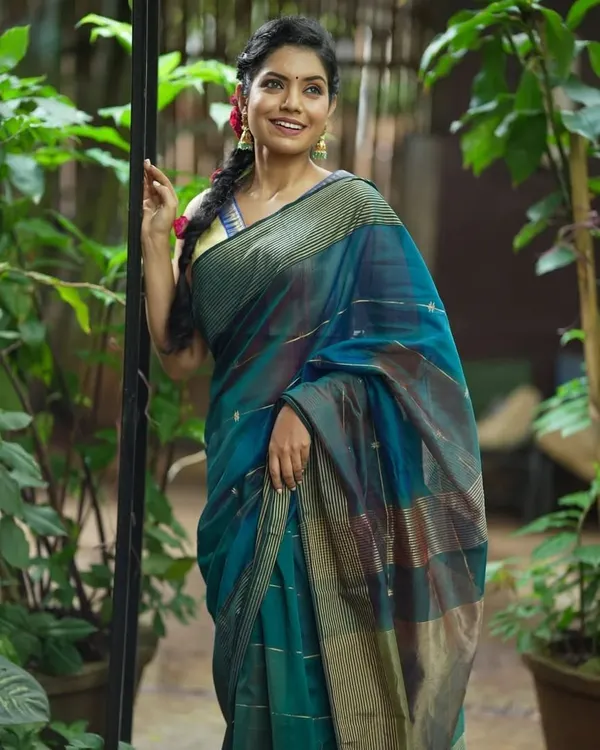 A model looking fresh and radiant in a teal blue Maheshwari silk cotton saree. The subtle stripes and lightweight fabric make it an ideal choice for comfortable, all-day wear.