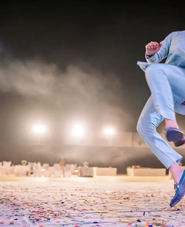 A groom's friend leaps in the air during an energetic sangeet dance performance. I capture these high-energy, candid moments that show the pure joy and fun of the celebration.