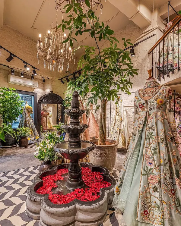 Welcome to The Vintage Garden. The centerpiece of our design is a black stone water fountain, creating an immediate sense of tranquility. We designed the entire retail space around creating an oasis-like experience, using vintage chandeliers, lush greenery, and a striking chevron floor to guide customers through the boutique.