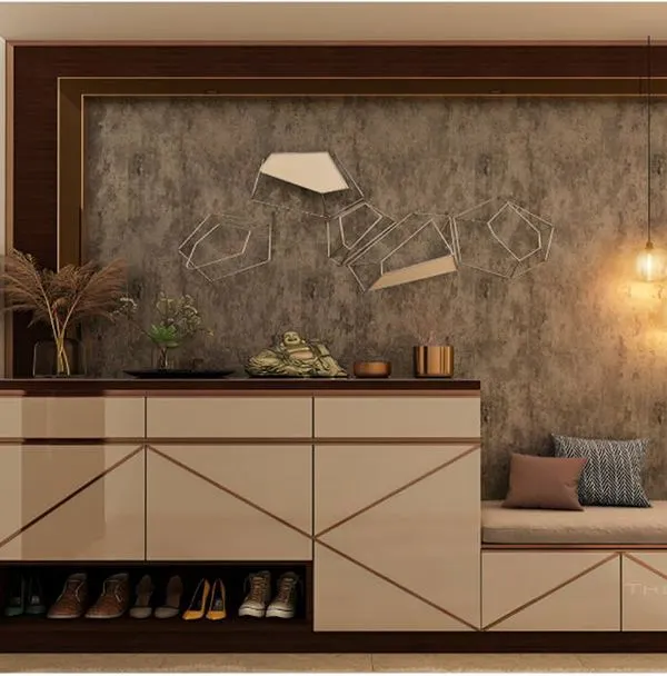 A stylish foyer unit with a built-in cushioned seat. The cabinet features a glossy finish with geometric gold inlay and an open shelf at the bottom for frequently used shoes.