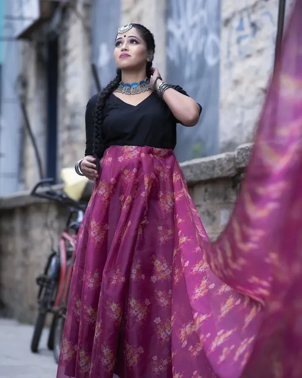 This is a modern fusion look, pairing a simple black top with a vibrant floral skirt. I styled the hair in a long, thick braid and used contemporary silver jewellery to complete this chic, indo-western outfit.