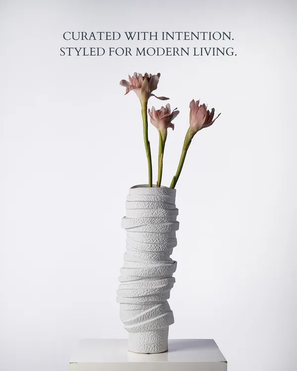 Curated with intention, styled for modern living. This white textured vase, holding delicate pink lilies, embodies the Faaya Focus ethos. Its wrapped, sculptural form adds a layer of artistry, making it a statement piece that feels both contemporary and timeless.